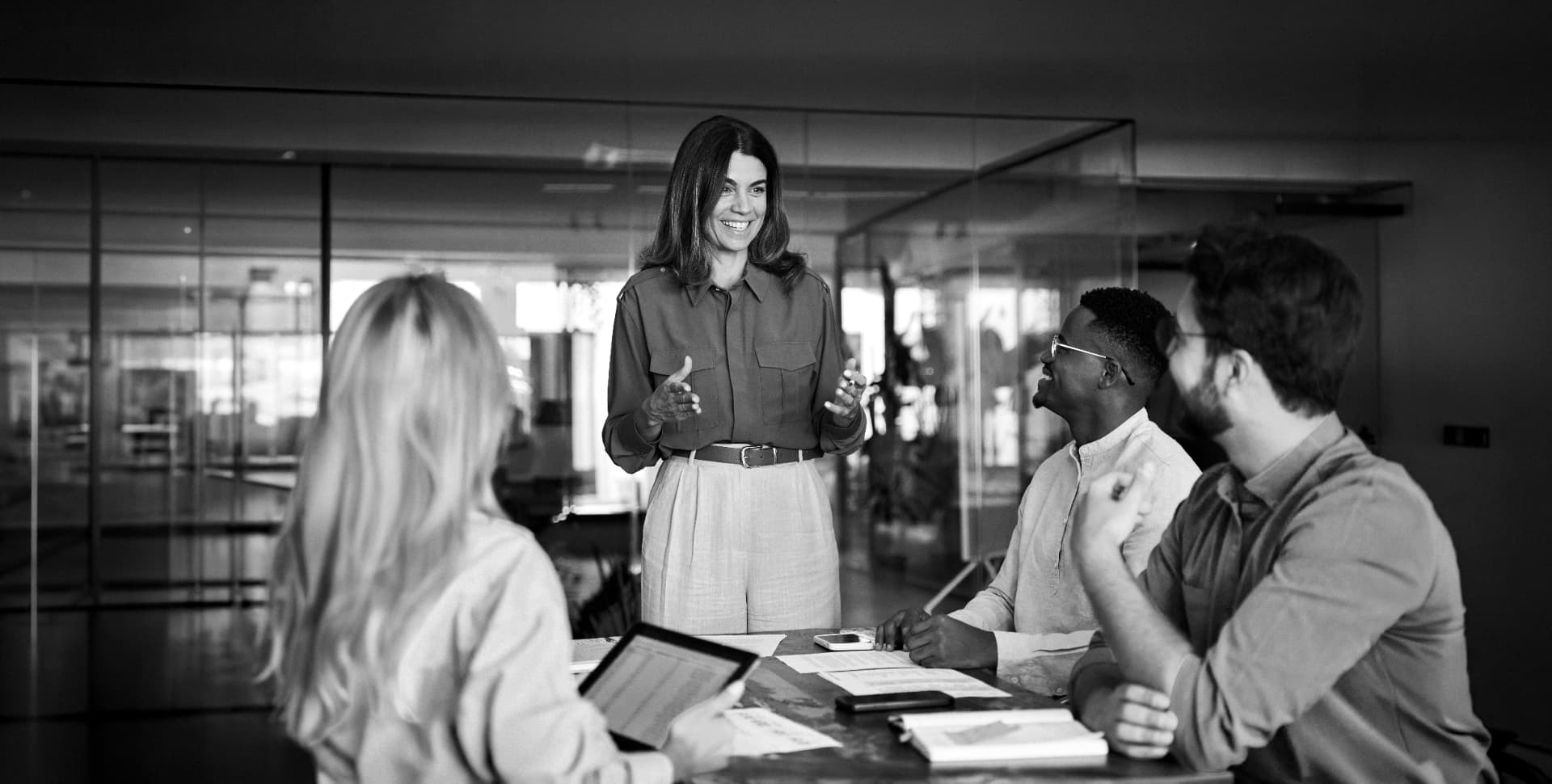 A colleague presenting to three colleagues gathered around a conference table